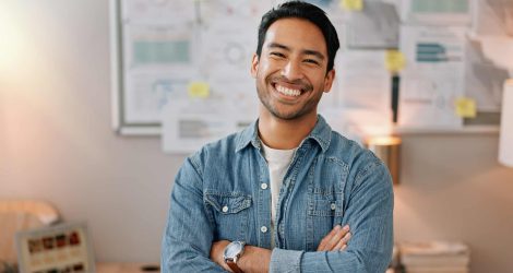 Business man, arms crossed and smiling face with creative worker and confident from admin consultant job. Happy, professional and portrait with entrepreneur employee for startup career at night.